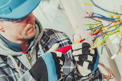 electricista profesional hurgando en enchufe